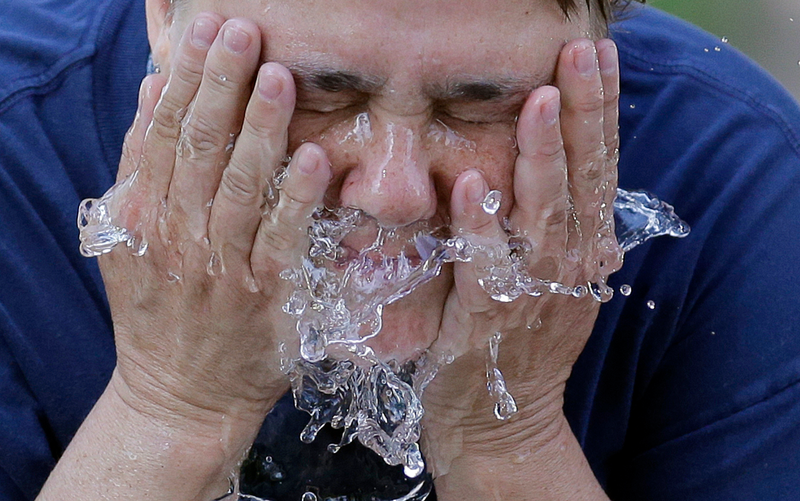 Un hombre refrescándose por las altas temperaturas. AP